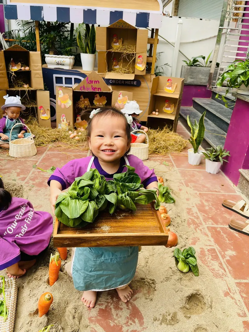 Bé hào hứng bê khay rau trong giờ trải nghiệm